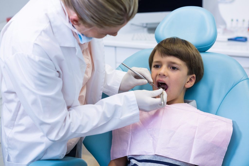boy receiving dental treatment by dentist 1.jpg